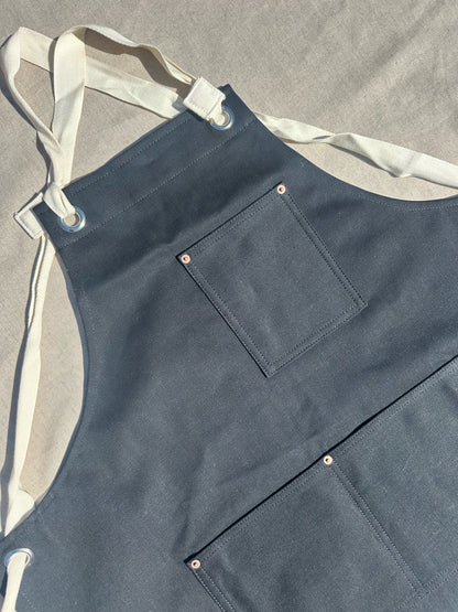 Blue apron with a pocket on a gray background